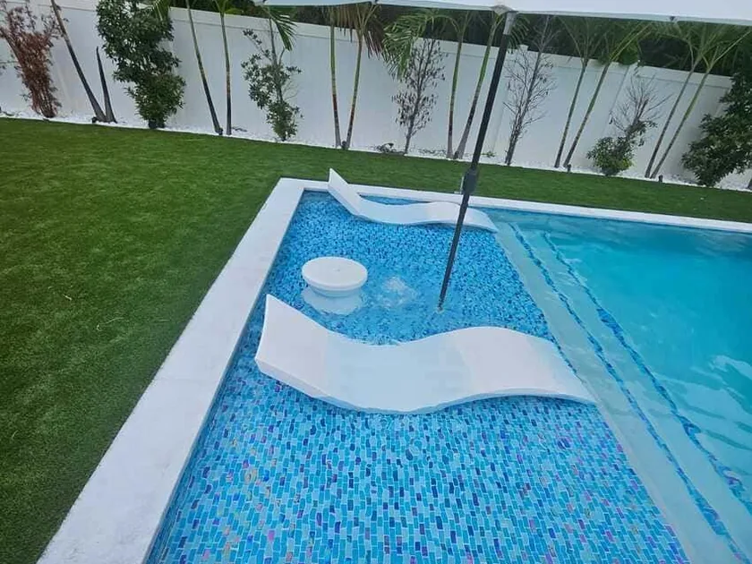 Rectangular pool with glass mosaic interior, sun shelf and two in-water loungers